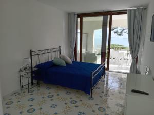- une chambre avec un lit doté d'un couvre-lit bleu dans l'établissement L’Oasi del Barone, à Villammare