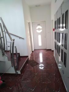 a hallway with stairs and a door with a window at Studio apartman MIR in Kanjiža