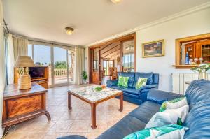 uma sala de estar com um sofá azul e uma mesa em Ideal Property Mallorca - Villa Gomila em Sa Pobla