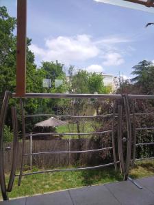 a metal gate with a view of a garden at Studio apartman MIR in Kanjiža