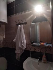 a bathroom with a sink and a mirror and a towel at Studio apartman MIR in Kanjiža