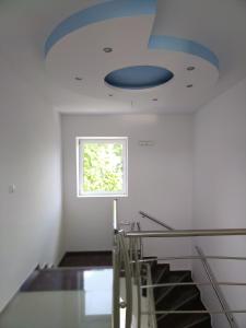 a staircase with a blue ceiling and a window at Studio apartman MIR in Kanjiža