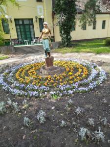 a woman standing in front of a flower clock at Studio apartman MIR in Kanjiža