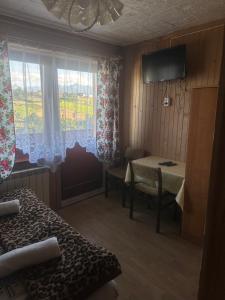 een kamer met een bed, een raam en een tafel bij Pokoje gościnne u Zofii in Bukowina Tatrzańska