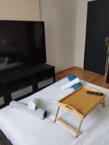 uma bandeja em cima de uma cama com uma televisão em Appartement Brest avec belles prestations em Brest