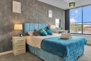 una camera da letto con un grande letto con cuscini blu di Penthouse With City Skyline Views - Free Parking - Balcony - King Size Bed - Netflix a Birmingham