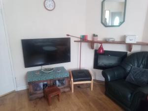 salon z kanapą, telewizorem i stołem w obiekcie Fifty-five w Bristolu
