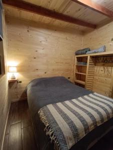 a bedroom with a bed in a wooden room at Cabañas los 7 lagos in Panguipulli