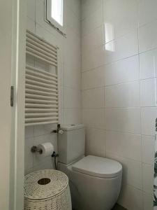 a white bathroom with a toilet and a window at Piso en pleno centro de Madrid in Madrid
