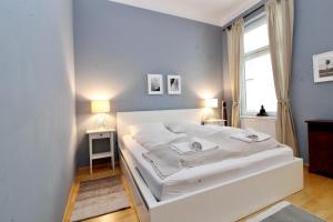 a white bed in a room with a window at Classy Apartment in the Heart of Vienna in Vienna