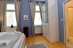ウィーンにあるClassy Apartment in the Heart of Viennaの青い壁のベッドルーム1室、ベッド1台、窓が備わります。