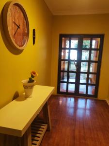 um quarto com um relógio na parede e uma mesa em Delightful Home em Pretoria