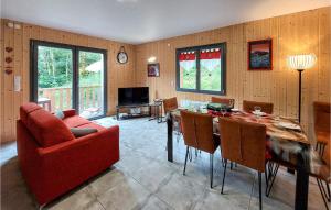 een woonkamer met een rode bank en een tafel bij Nice Home In Mont-dore With Wifi in Le Mont-Dore