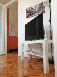 a living room with a tv on a white table at Apartman studio Oranž in Kladovo