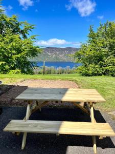 a wooden picnic table with a view of a lake at 1 Loch Ness Heights in Inverness