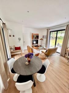 a living room with a table and chairs at Lodge avec spa au coeur de Brocéliande in Beignon