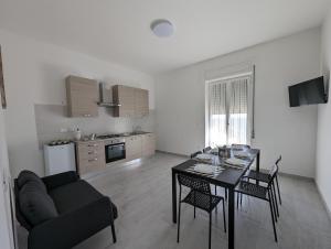 uma sala de estar com uma mesa de jantar e uma cozinha em Holiday House em Villamagna