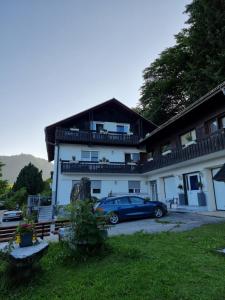 Niebieski samochód zaparkowany przed domem w obiekcie Ferienhaus Burgblick w mieście Treffen am Ossiacher See