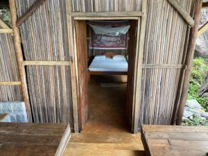 Una pequeña casa de madera con una cama. en Makako Lodge, en Ampangorinana