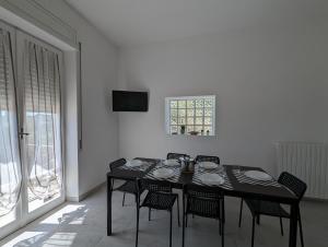 uma sala de jantar com uma mesa preta e cadeiras em Holiday House em Villamagna