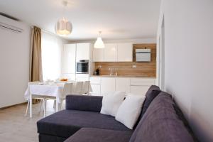 a living room with a couch and a kitchen at Rina Apartment- with barbecue and free parking in Kaštela