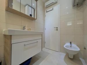 uma casa de banho branca com um lavatório e um WC em Apartments Sea View em Rtina
