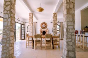 a dining room with a table and chairs and a fireplace at villa Floratus in Essaouira