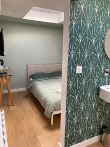 1 dormitorio con 1 cama y baño con lavamanos en Central ensuite guest unit with free on-street parking, en Brighton & Hove