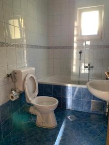 uma casa de banho com um WC, um lavatório e uma banheira em Room Ivana em Neum