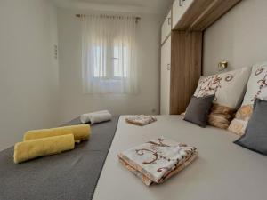 um quarto com uma grande cama branca e 2 almofadas em Apartments Sea View em Rtina
