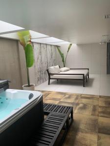 Habitación con baño con bañera profunda y sofá. en Confort suite La Carolina, en Quito