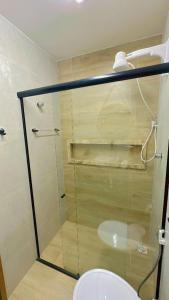een badkamer met een toilet en een glazen douche bij Sunsand Beach Suítes e Hostel in Camocim