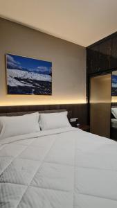 een slaapkamer met een groot wit bed in een kamer bij 3Br Sky House BSD Apartment Brandnew and Cozy in Samporo