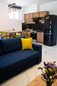 a living room with a blue couch and a kitchen at Elias Studio - Near to the port of Rafina and the Airport of Athens in Áyios Spirídhon