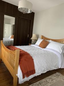 1 dormitorio con 1 cama grande con sábanas blancas en Adanhouse-stockland spacious 5 bedroom house sleeps 12 private garden, en Cardiff