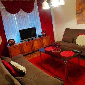 ein Wohnzimmer mit einem Sofa und einem TV in der Unterkunft Apartman stan na dan Sarajevo in Sarajevo