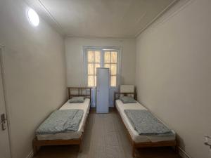 een kamer met 2 bedden en een koelkast. bij Bkenkember Aprt in Antwerpen