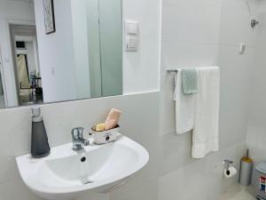 bagno bianco con lavandino e specchio di Techas City Center Luxurious Suites & Rooms a Praia