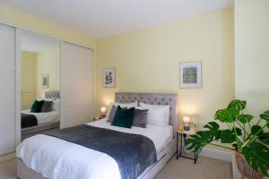ein Schlafzimmer mit einem großen weißen Bett mit grünen Kissen in der Unterkunft Cardiff City Centre Large 2 Bedroom Apartment with Privat Parking in Cardiff