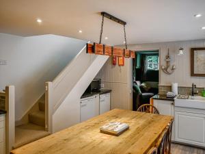 a kitchen and dining room with a staircase in a house at Ewden in Robin Hood's Bay