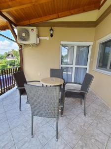 a patio with chairs and a table and a fan at Villa Terra in Hévíz