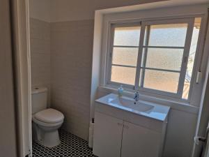 ein Bad mit einem WC, einem Waschbecken und einem Fenster in der Unterkunft Alojamento Mercado Norte in Lissabon