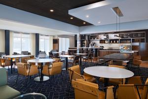 a restaurant with tables and chairs in a room at Courtyard by Marriott Dallas Richardson at Spring Valley in Richardson