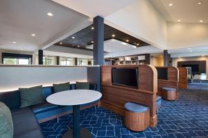 Courtyard by Marriott Dallas Richardson at Spring Valley في ريتشاردسون: غرفة انتظار مع أريكة وتلفزيون