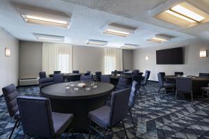 a conference room with tables and chairs and a screen at Courtyard by Marriott Dallas Richardson at Spring Valley in Richardson