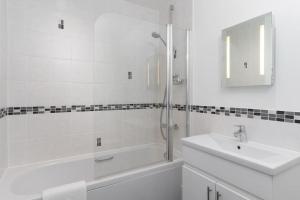 a white bathroom with a sink and a shower at Barepta Cove, Stunning Carbis bay apartment in Carbis Bay +21 photos