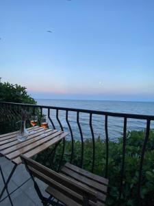 a table with two glasses of wine on a balcony overlooking the ocean at Apartment in a beach house Old town Nessebar in Nesebar