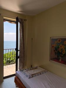 1 dormitorio con cama y vistas al océano en Apartment in a beach house Old town Nessebar en Nesebar