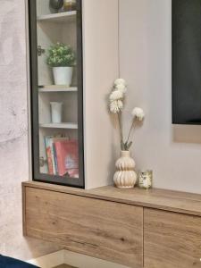 a vase with flowers sitting on a dresser next to a mirror at Apartments Jasna in Rovinj