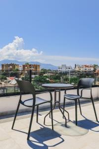 2 sillas y mesa en un balcón con vistas en Vullkan Hotel en Ksamil